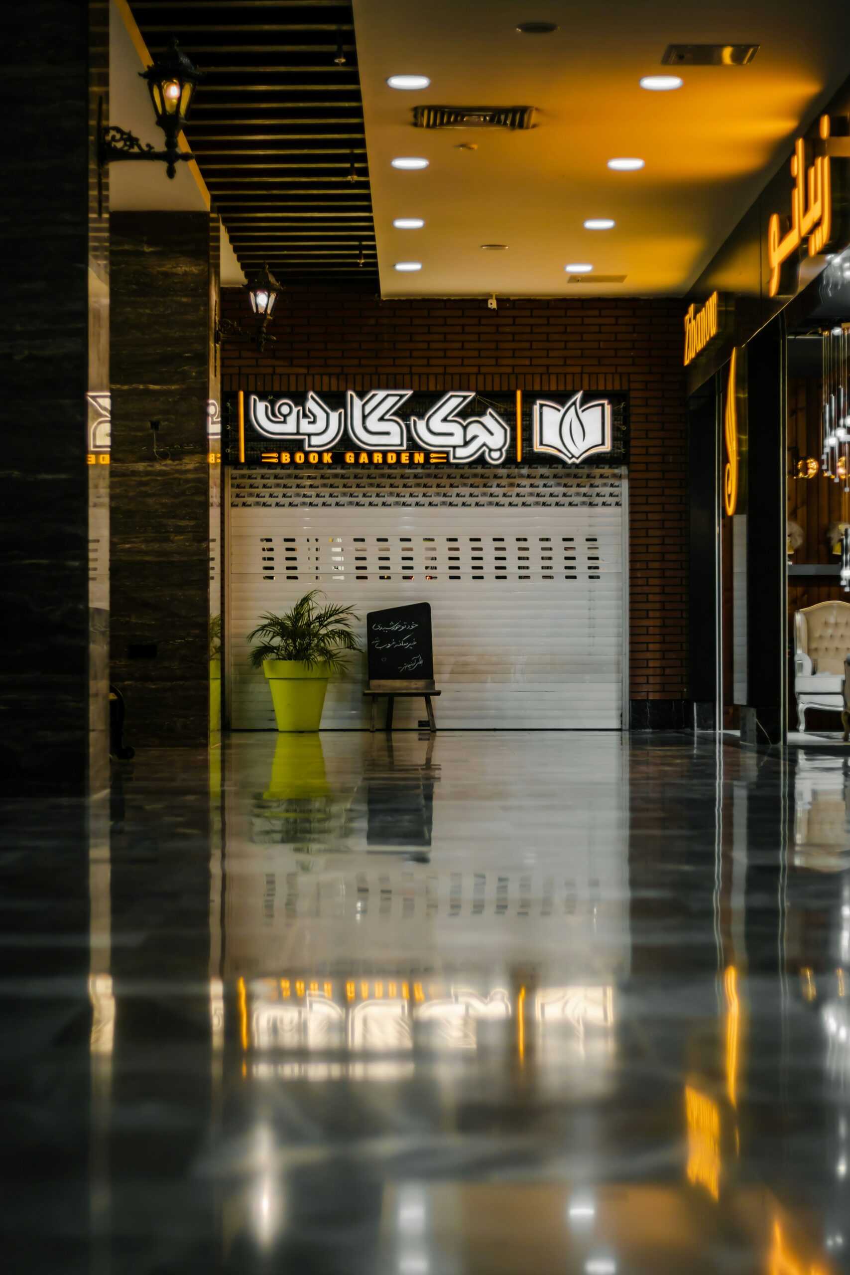 a building with a large shiny floor and a yellow vase